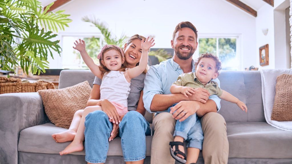 Happy family portrait, parents and kids relax on living room sofa, couch and together for love, care and happiness in Australia. Smile mom, dad and excited children in lounge, family home and house